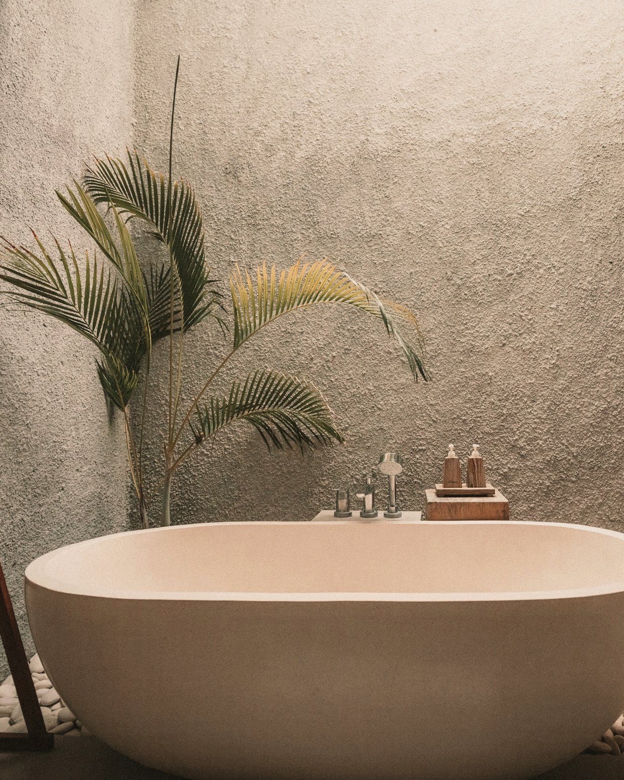A sculptural stone bath against hand-troweled travertine.