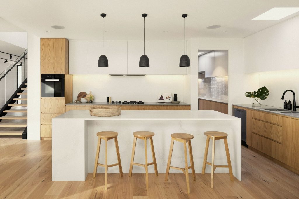 A calm kitchen in pale oak and limestone with a long island and pendant lights.